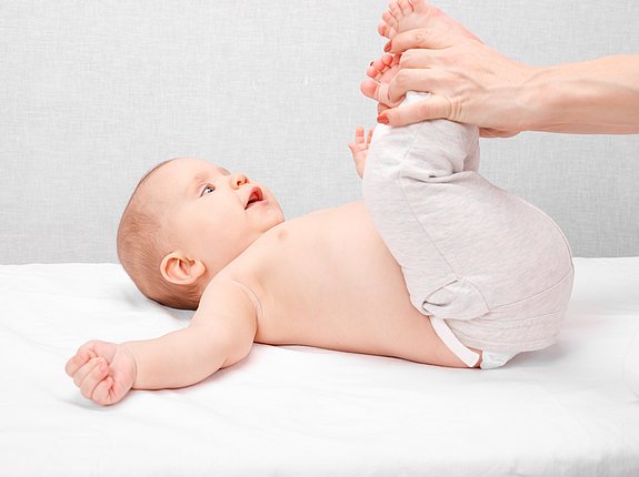 Osteopathin gibt Baby eine Bein-Massage