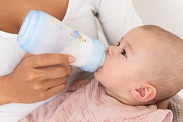 Mutter füttert liebevoll ihr Baby mit einer MAM Trinkflasche
