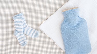 Hellblaue Wärmflasche hilft gegen Baby-Blähungen.