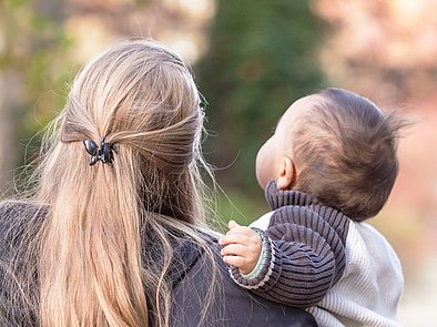 Rückansicht von einer Mutter und ihrem Baby.