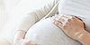 Mutter streichelt liebevoll ihren Baby-Bauch.