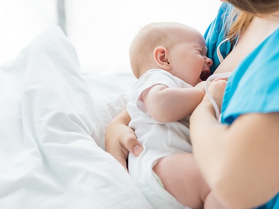 Baby schreit während es gestillt wird.