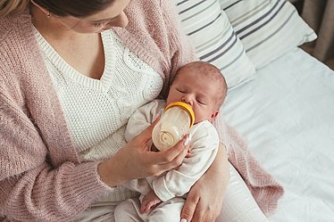 Mutter füttert Baby mit Flasche