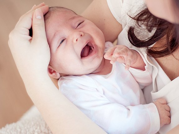 Schreiendes Baby wird von Mutter getröstet