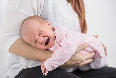 Der Fliegergriff ist ein bewährtes Hausmittel bei Baby-Blähungen.